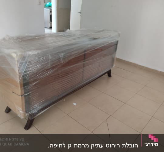 שידה עטופה בניילון נצמד על רצפת אריחים